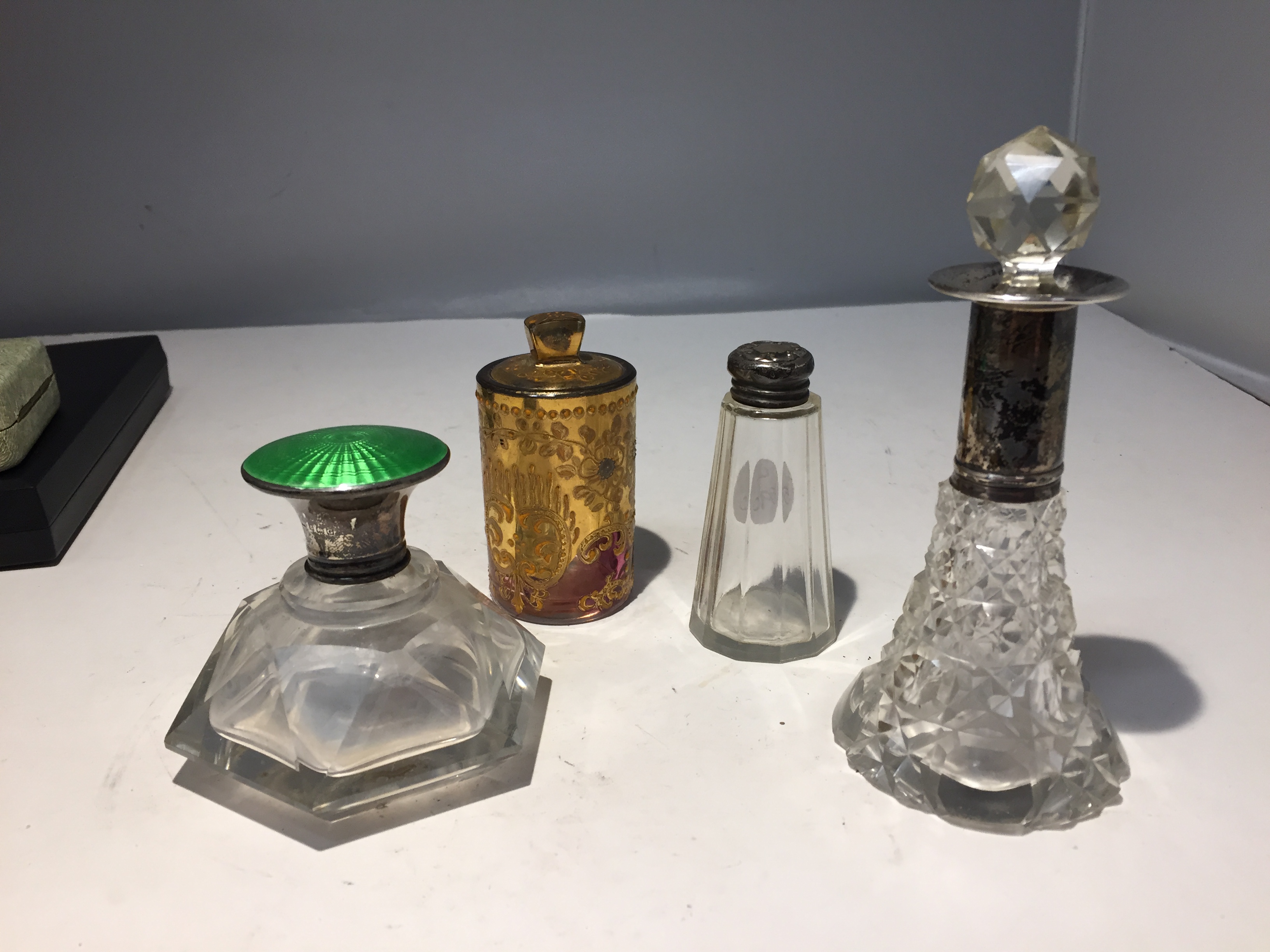 FOUR VINTAGE PERFUME BOTTLES TO INCLUDE TWO WITH HALLMARKED TOPS, ONE WITH A HALLMARKED COLLAR AND A
