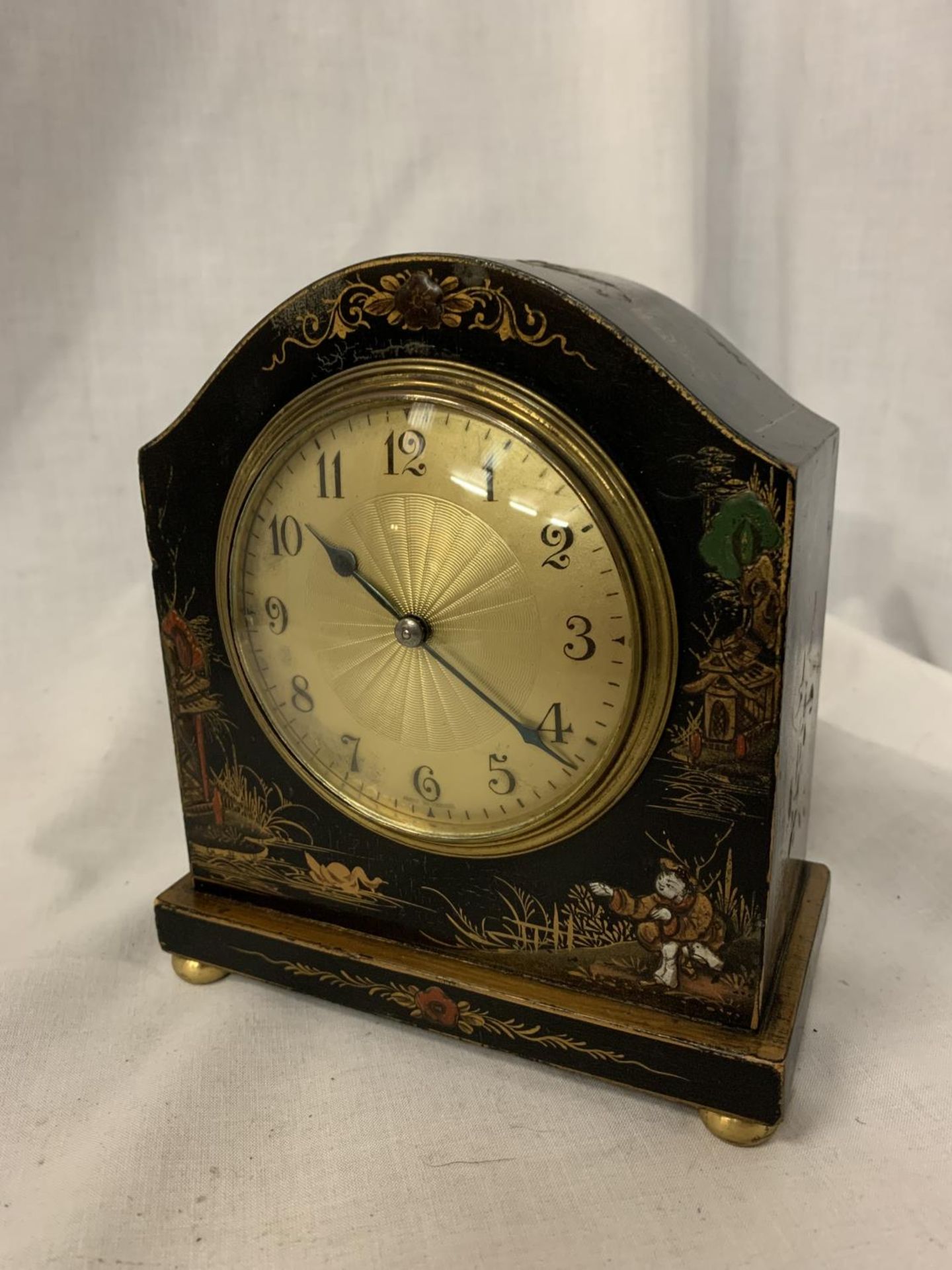 AN EBONISED MANTLE CLOCK WITH ORIENTAL DESIGN