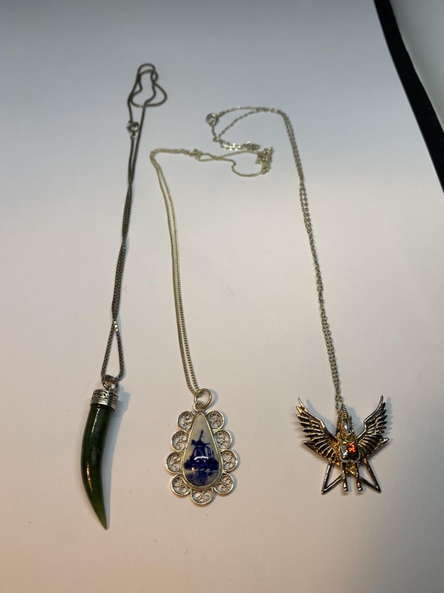 THREE SILVER NECKLACES WITH PENDANTS TO INCLUDE A UNICORN, DELPH PENDANT AND JADE COLOURED HORN