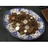 A BLUE AND WHITE PLATE CONTAINING A LARGE AMOUNT OF PRE DECIMAL COINS, PENNIES, SHILLINGS,