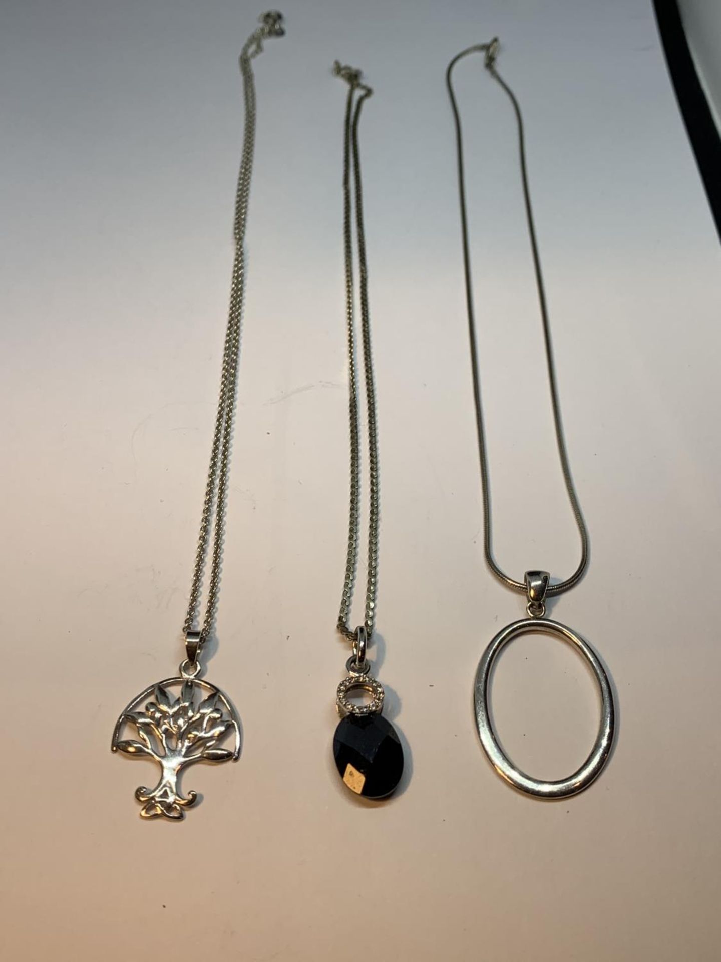 THREE SILVER NECKLACES WITH PENDANTS