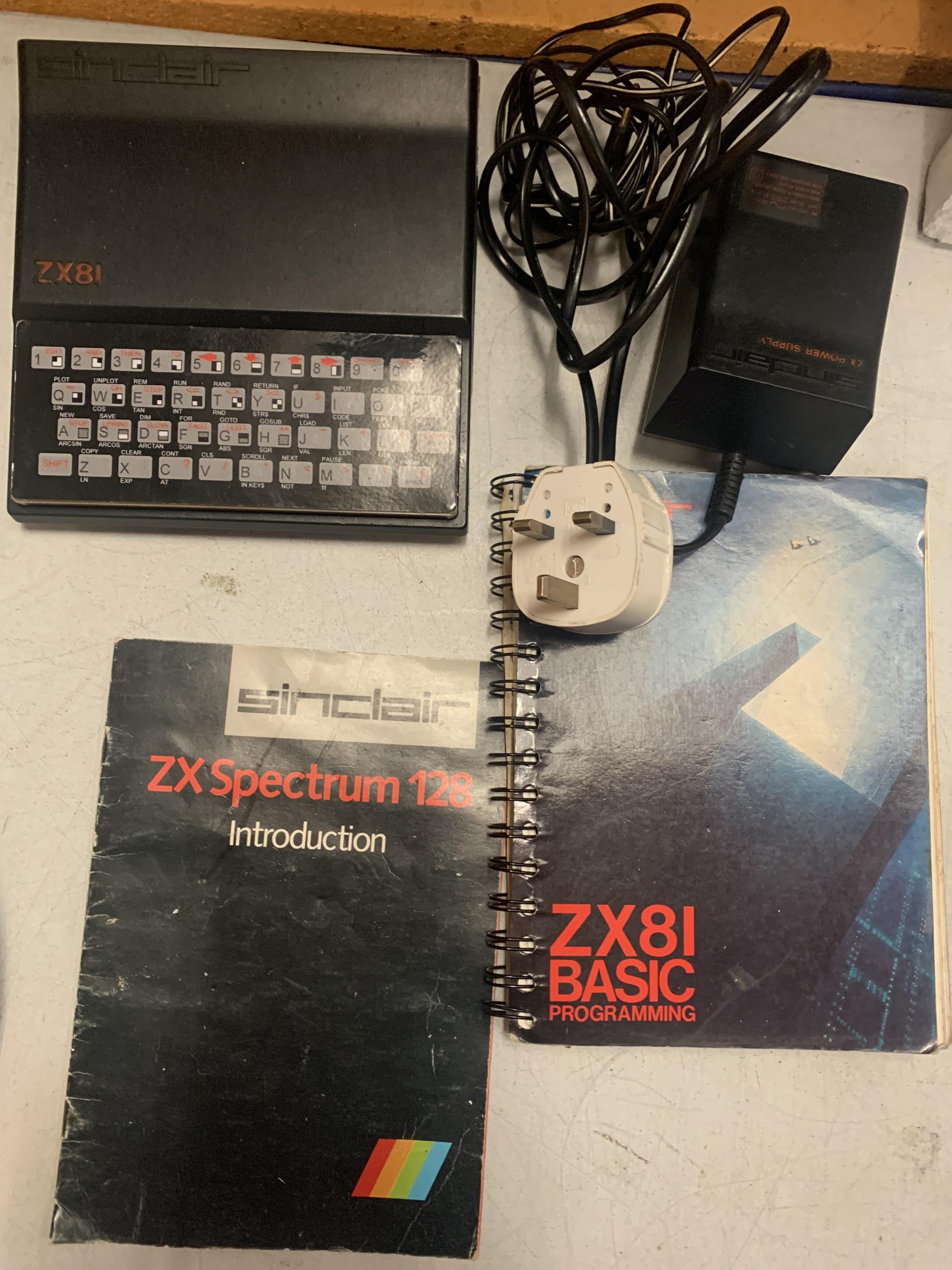 A SINCLAIR ZX81 WITH GUIDES AND POWER SUPPLY