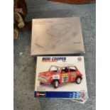 A BOXED BURAGO MINI COOPER AND A JOHN LEWIS ASTON MARTIN V12 VANQUISH METAL REPLICA KIT