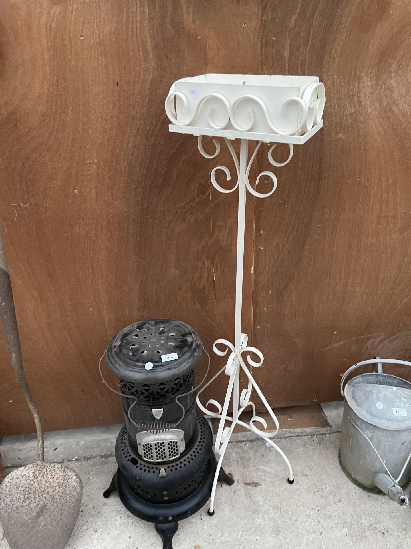 A WHITE PAINTED METAL PLANT STAND AND A VINTAGE VALOR HEATER