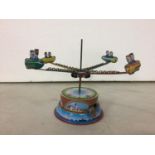 A TIN PLATE MERRY-GO-ROUND TOY