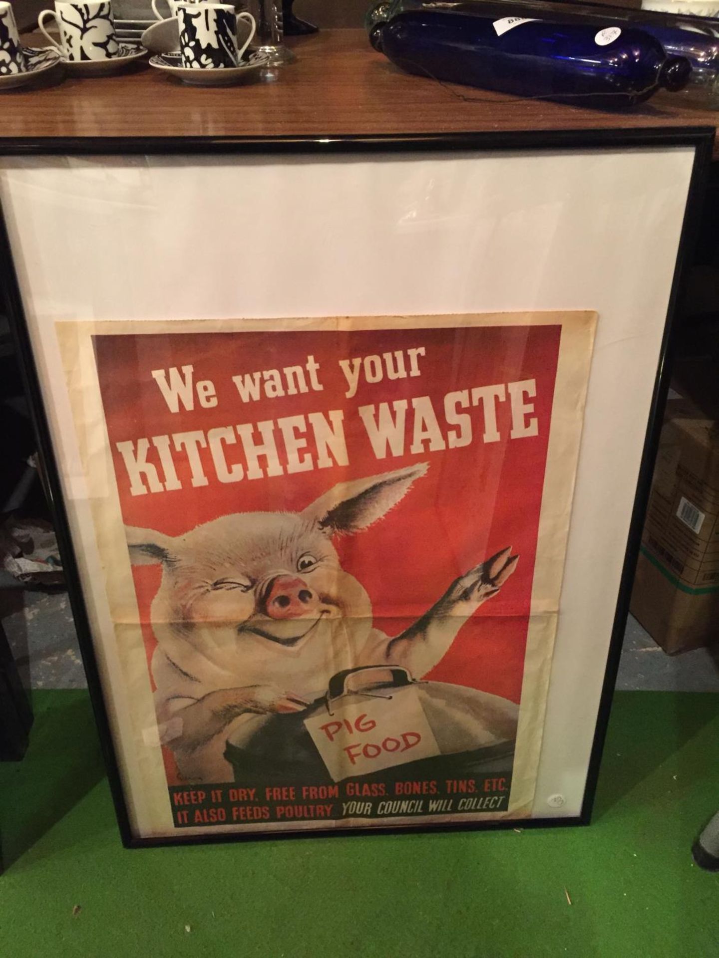 A WORLD WAR 11 FRAMED PROPOGANDA POSTER ABOUT KEEPING KITCHEN WASTE FOR THE PIGS