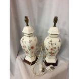 A PAIR OF DECORATIVE CERAMIC TABLE LAMPS WITH A FLORAL DESIGN (A/F - HAIRLINE CRACK)