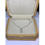 AN 18 CARAT WHITE GOLD NECKLACE WITH A PENDANT INCORPORATING FOUR DIAMONDS WITH A 50CM CHAIN IN A