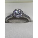 A PLATINUM AND DIAMOND HALO RING SIZE M/N IN A PRESENTATION BOX