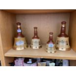 A COLLECTION OF FOUR GRADUATED BELLS SCOTCH WHISKEY DECANTORS