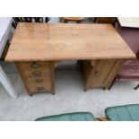 A VICTORIAN PITCH PINE DOUBLE PEDESTAL DESK WITH FOUR DRAWERS WITH BRASS SCOOP HANDLES AND ONE