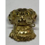 A SILVER GILT PENDANT IN THE FORM OF A DOGS HEAD WITH A STICK