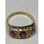 A 9 CARAT GOLD RING WITH THREE IN LINE RUBYS AND FOUR DIAMONDS SIZE P