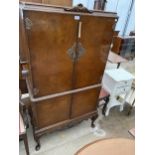 A WALNUT COCKTAIL CABINET WITH MIRRORED GLASS SLIDE ON CABRIOLE LEGS, 32" WIDE