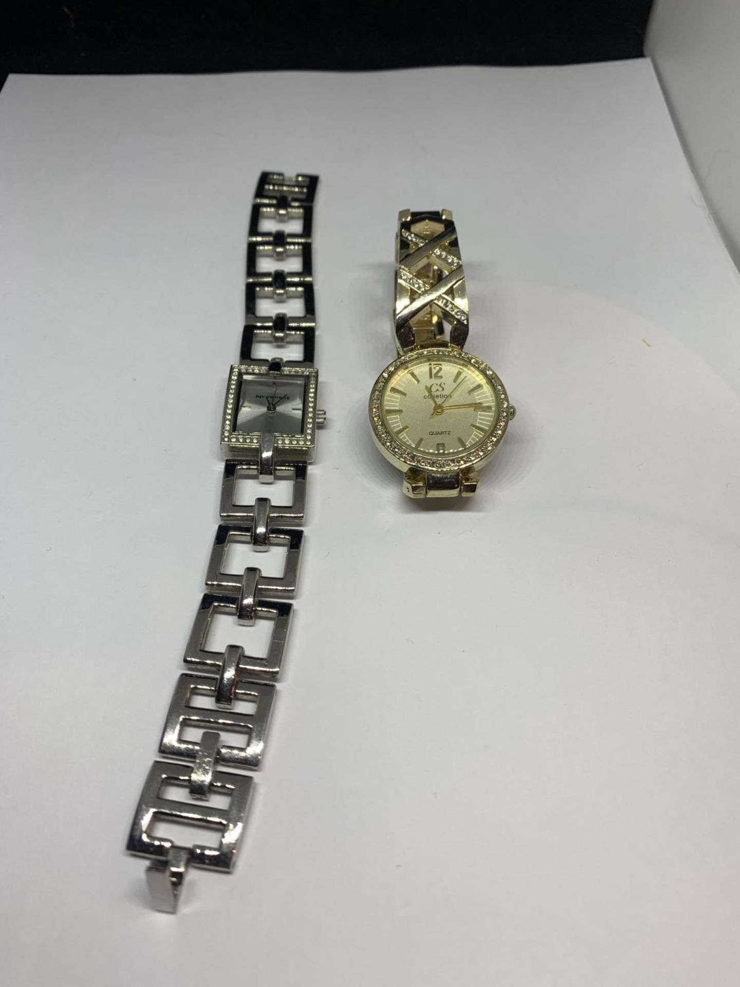 TWO DECORATIVE WRIST WATCHES WITH CLEAR STONE DECORATION ONE WITH A RECTANGULAR FACE AND A