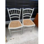 A PAIR OF PAINTED SPINDLE-BACK BEDROOM CHAIRS WITH CANE SEATS