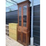 A NARROW EDWARDIAN OAK TWO DOOR BOOKCASE ON TWO DOOR BASE ENCLOSING SINGLE DRAWER, 27" WIDE