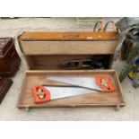 A VINTAGE WOODEN JOINERS CHEST WITH AN ASSORTMENT OF TOOLS TO INCLUDE SAWS, A TAPE MEASURE AND A