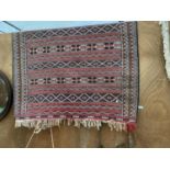 A RED PATTERNED FRINGE RUG