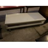 A TWO TIER KULL MELAMINE COFFEE TABLE ON WHEELS, 58.5 X 23"