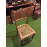 A PINE CHAIR WITH A CARVED BACK STRETCHER AND A RATTAN SEAT