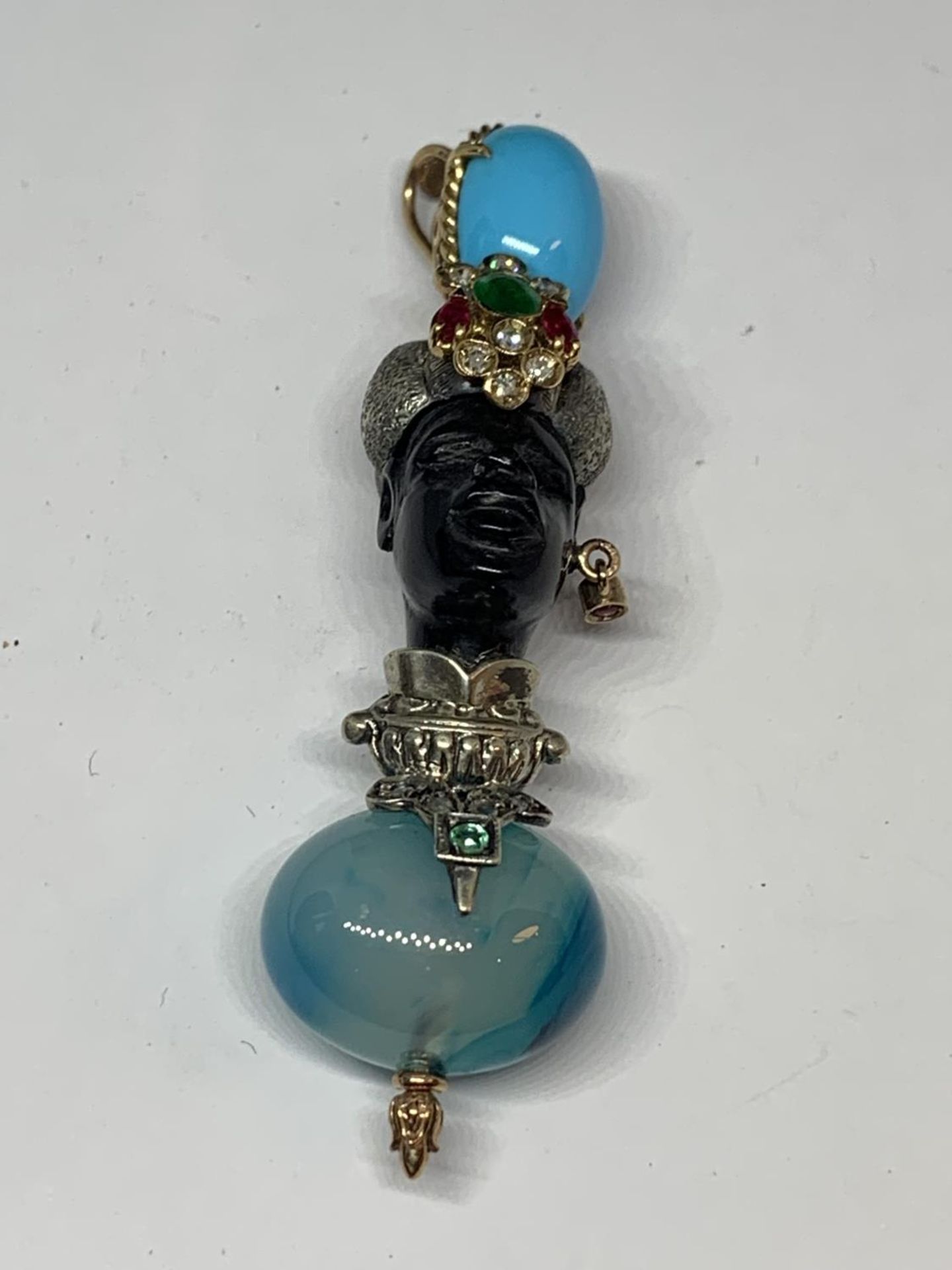 A BLACKAMORE PENDANT OF AN AFRICAN TRIBAL FIGURE WITH RUBYS, EMERALDS AND TURQUOISE STONES BY