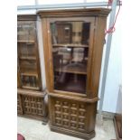 A YOUNGER GLAZED CORNER CUPBOARD ON BASE WITH CARVED PANEL DOOR, 32" WIDE