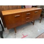 A RETRO TEAK SIDEBOARD ENCLOSING THREE DRAWERS AND THREE CUPBOARDS