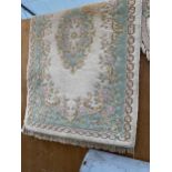 A GREEN AND CREAM PATTERN FRINGED RUG