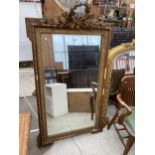 A 19TH CENTURY GILT FRAMED WALL MIRROR WITH CARVING TO THE TOP RAIL