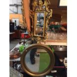 TWO GILT FRAMED MIRRORS. ONE OVAL AND THE OTHER ORNATE RECTANGULAR WITH AN ANGEL TO THE TOP