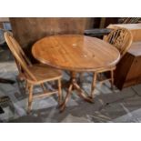 A MODERN PINE DROP-LEAF TABLE, 36" DIAMETER AND TWO WHEEBACK CHAIRS