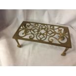 AN ORNATE BRASS TRIVET