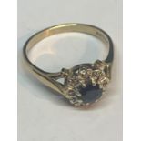 A 9 CARAT GOLD RING WITH A CENTRE SAPPHIRE SURROUNDED BY DIAMONDS IN A FLOWER DESIGN SIZE Q IN A