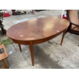 A RETRO OVAL TEAK EXTENDING DINING TABLE - EXTENDING MECHANISM REQUIRES ATTENTION