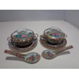A PAIR OF ORIENTAL LIDDED BOWLS AND SAUCERS WITH SPOONS