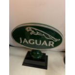 A LARGE CAST JAGUAR SIGN ON A WOODEN BASE