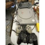 A PLAYSTATION 1 WITH THREE CONTROLLERS