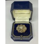 AN 18 CARAT WHITE AND YELLOW GOLD ART DECO CLUSTER RING WITH A CENTRE DIAMOND, SIX SURROUNDING