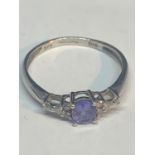 A 9 CARAT WHITE GOLD RING WITH A SINGLE AMETHYST SURROUNDED BY DIAMONDS SIZE L/M IN A PRESENTATION