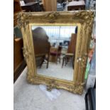 A 19TH CENTURY ORNATE GILT FRAMED WALLMIRROR, 54 X 42"