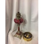 AN OIL LAMP WITH CRANBERRY GLASS, AN ARTILLIARY SHELL BASE AND A PEN KNIFE