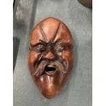 A CARVED WOODEN MASK OF AN ORIENTAL MAN