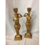 A PAIR OF GILT CANDLESTICKS MODELLED AS CLASSICAL FIGURES. HEIGHT 39CM