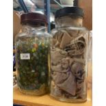 TWO LARGE JARS OF MARBLES - ONE WITH SMALL HESSIAN BAGS