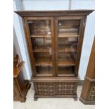 A YOUNGER TWO DOOR GLAZED CABINET ON BASE WITH CARVED PANEL DOORS, 40" WIDE