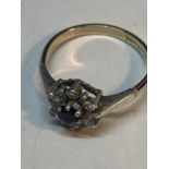 A 9 CARAT GOLD AND SILVER RING WITH A CENTRE BLUE STONE SURROUNDED BY CLEAR STONES SIZE M/N IN A