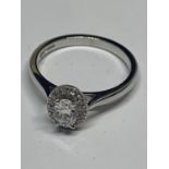 A PLATINUM AND DIAMOND OVAL HALO RING SIZE N/O IN A PRESENTATION BOX