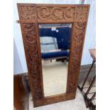 A HEAVILY CARVED VICTORIAN OAK WALL MIRROR, 48 X 24"