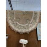 AN OVAL CREAM PATTERNED FRINGE RUG